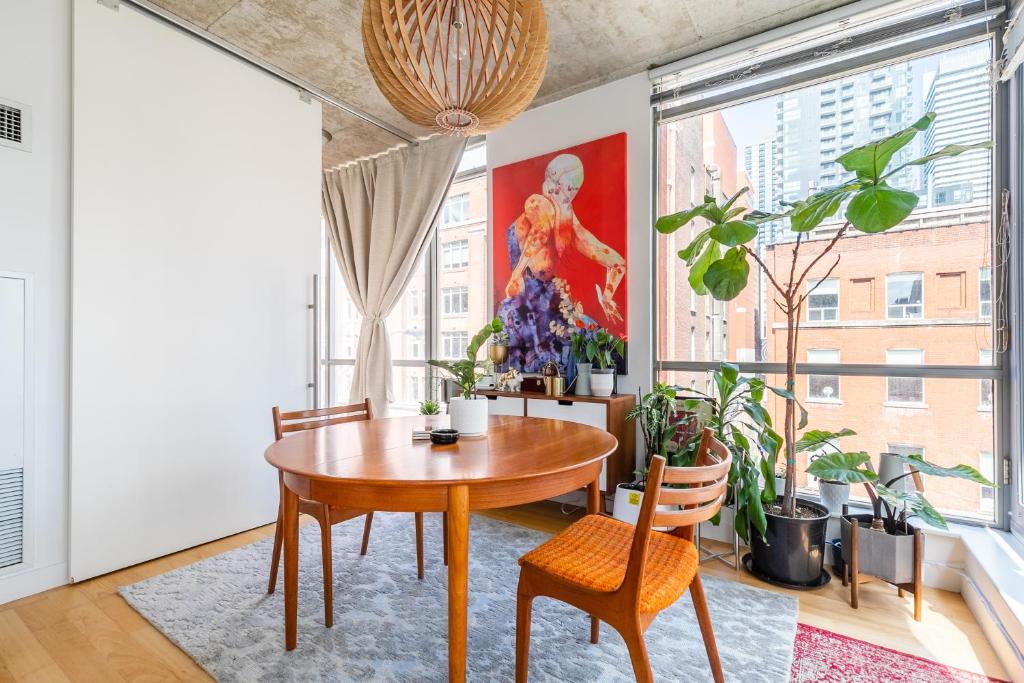 a dining room with a table and some plants at Spacious and Quiet Corner Apartment Downtown Toronto in Toronto