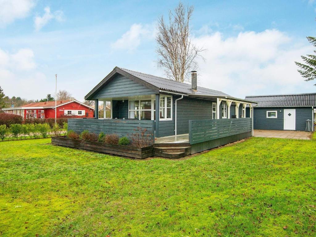 une maison avec une pelouse verte devant elle dans l'établissement Holiday home Haderslev XXXIII, à Haderslev