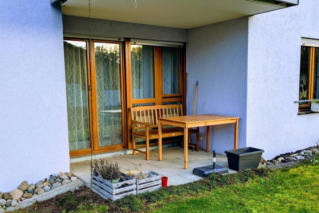 a patio with a table and a bench on a house at Helle Terrassenwohnung am Waldrand in Nürtingen