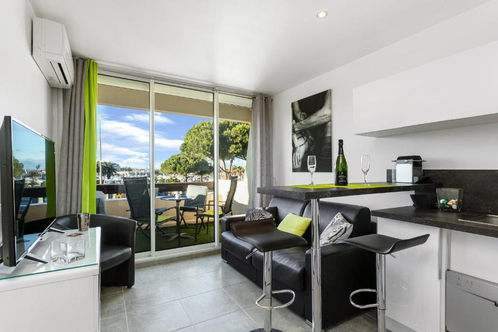 a kitchen and living room with a table and chairs at Village Naturiste - Le Caresse Port Nature Luxe in Cap d'Agde