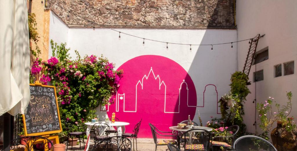 a pink door in a building with tables and chairs at Hotel Punto 79 in San Miguel de Allende