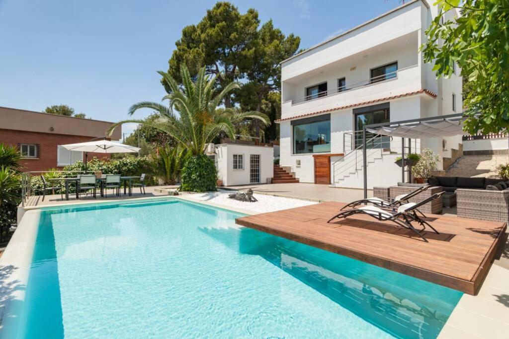 Moderna villa con piscina y amplio jardín في كاستيلديفِيلس: مسبح امام بيت