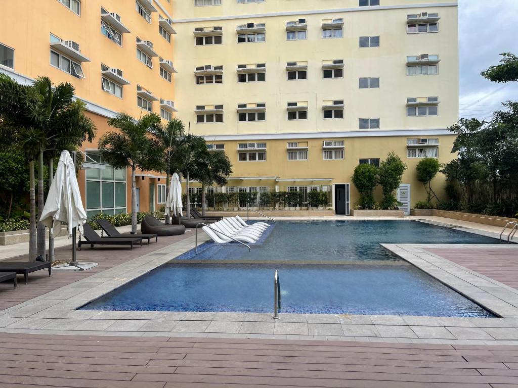 a swimming pool in front of a building at Khentdrick's Place at Holland Park Southwoods in Biñan