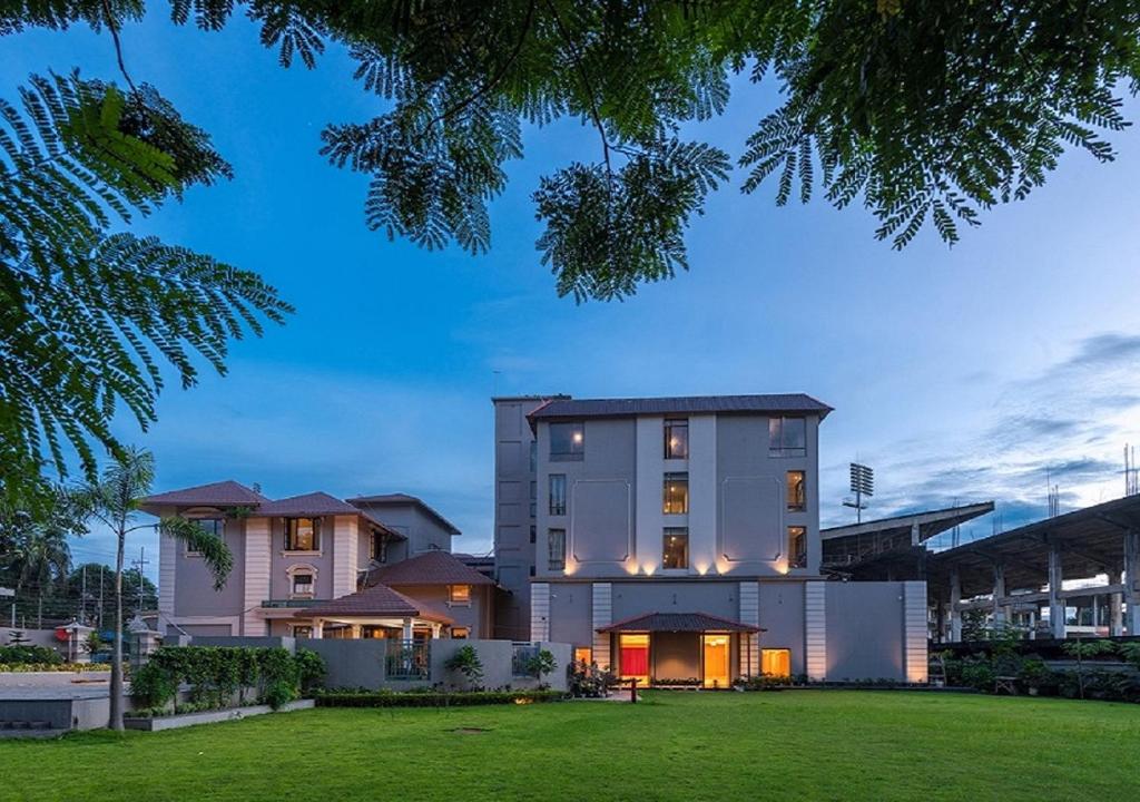 Hotel Cachar Club في سيلكار: منزل أمامه حديقة خضراء