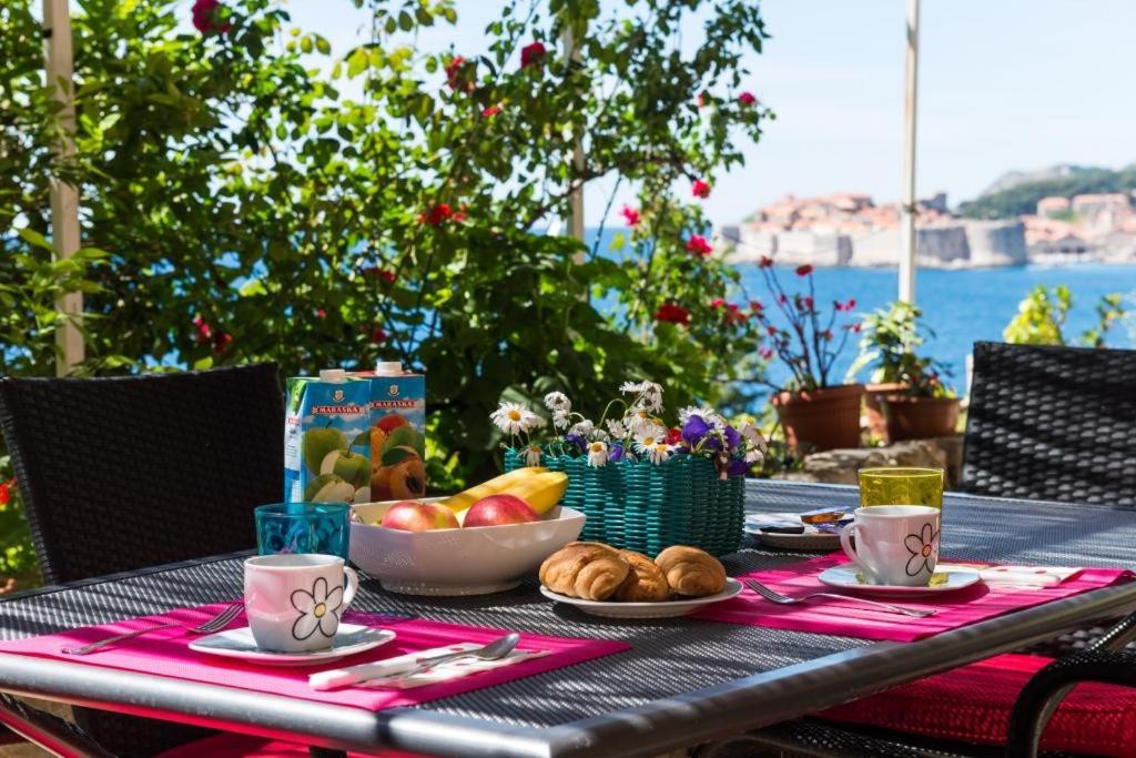 una mesa con un bol de fruta y un plato de pan en Apartment Helena, en Dubrovnik