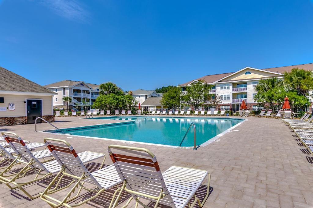 einen Pool mit Liegestühlen vor einem Gebäude in der Unterkunft Havens 712 Condo in Myrtle Beach