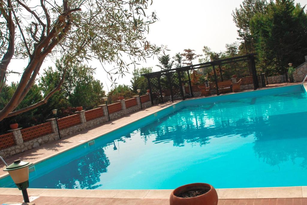 a large blue swimming pool with a fence around it at B&B Villa Sorriso in Licata