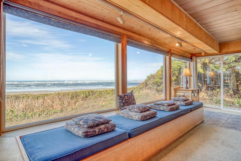 Cette chambre dispose d'un siège près de la fenêtre offrant une vue sur l'océan. dans l'établissement Seawoods, à Waldport