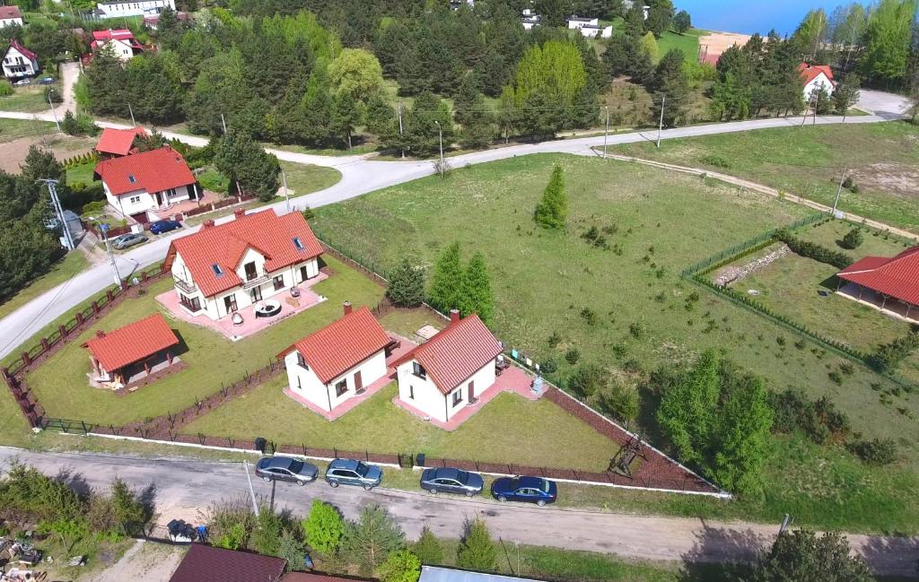 uma vista superior de uma grande casa com telhados vermelhos em Komfortowe domki letniskowe nad jeziorem na Mazurach 2 em Kruklanki