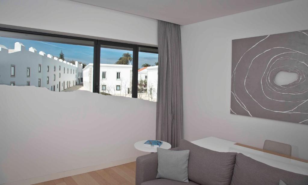 a living room with a couch and a large window at Pestana Cidadela Cascais - Pousada & Art District in Cascais