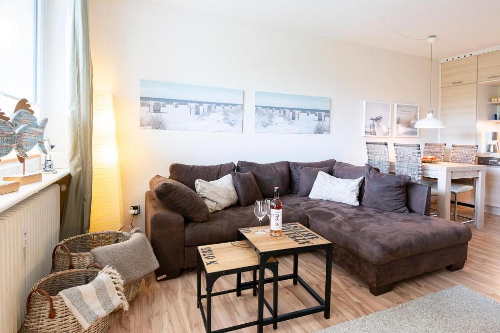 un soggiorno con divano marrone e tavolo di Driftberg 1 Haus A Wohnung 24 a Grömitz