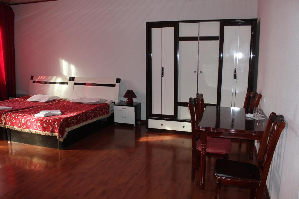 1 dormitorio con cama, mesa y escritorio en Pekin Hotel, en Temirtaū