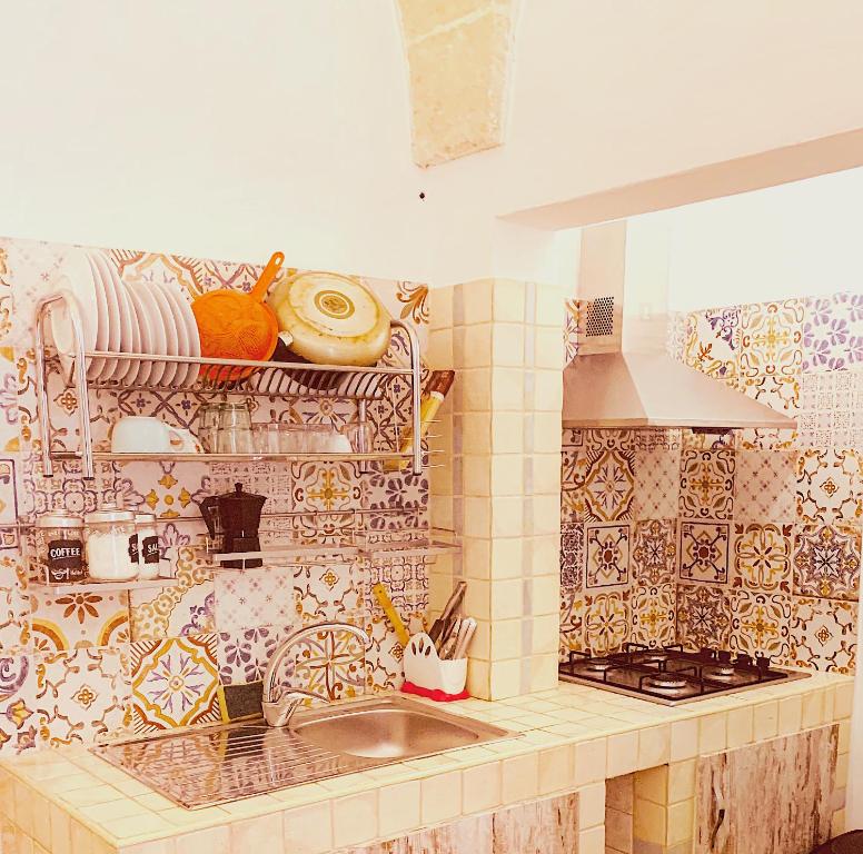 cocina con fregadero y pared de azulejos en Appartamento Bax 1, en Francavilla Fontana