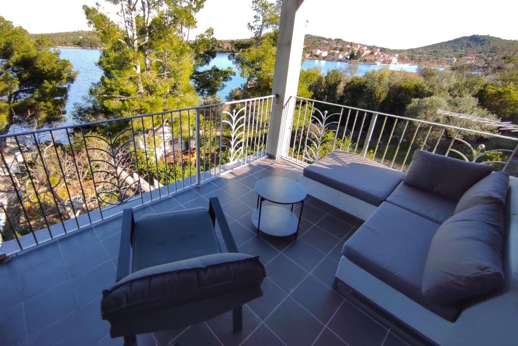 a balcony with a couch and chairs and a view of the water at Feel Dugi Otok - Apartment Sofia in Luka