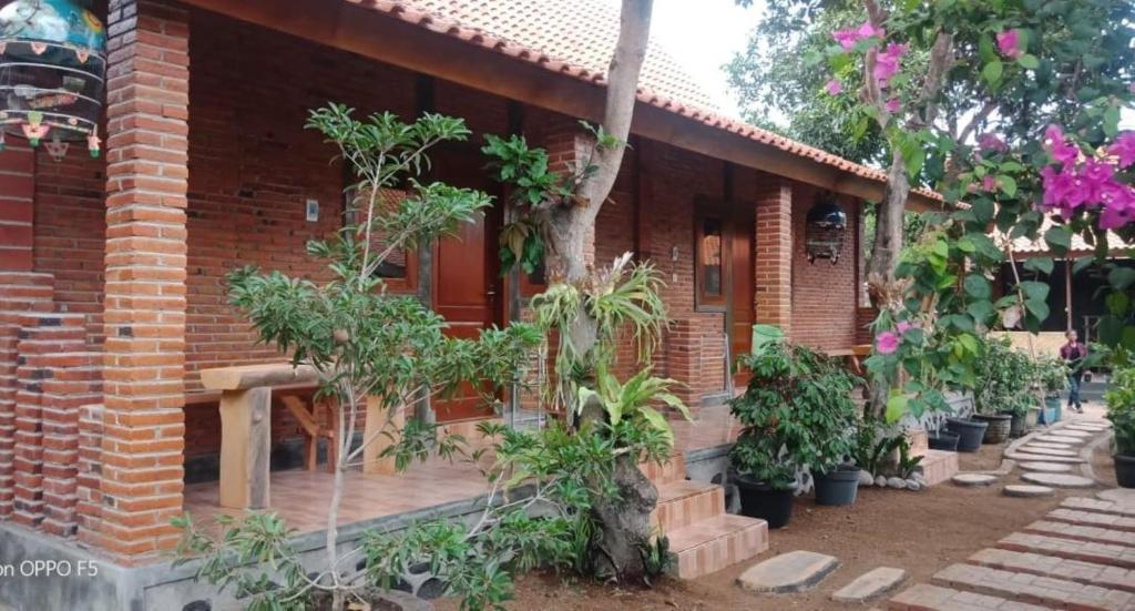 a brick house with trees in front of it at Nita's Homestay Banyuwangi in Banyuwangi