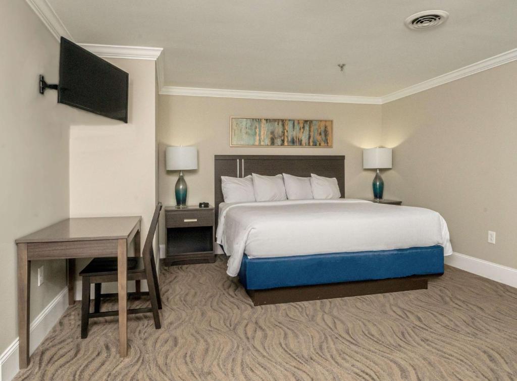 a hotel room with a large bed and a desk at Bask Hotel at Big Rock Landing in Morehead City