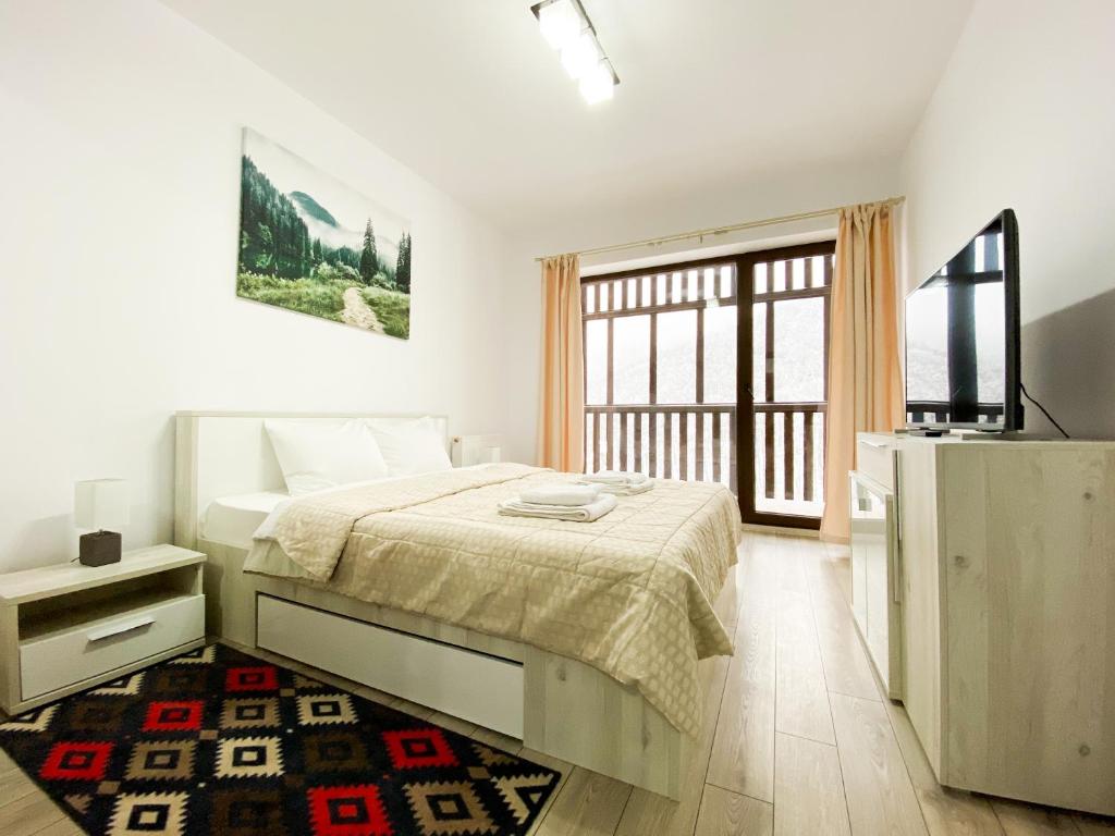 1 dormitorio con 1 cama y TV en Forest View Oasis, en Brasov