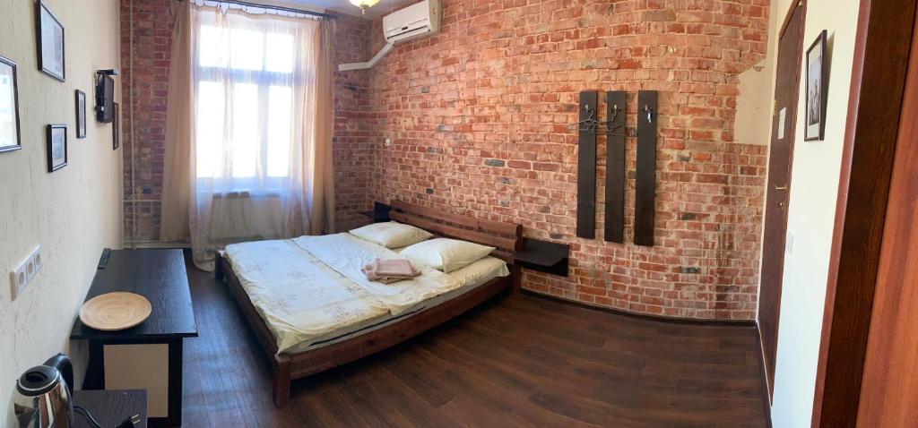 1 dormitorio con cama y pared de ladrillo en Kotsarskaya street 19 en Járkov