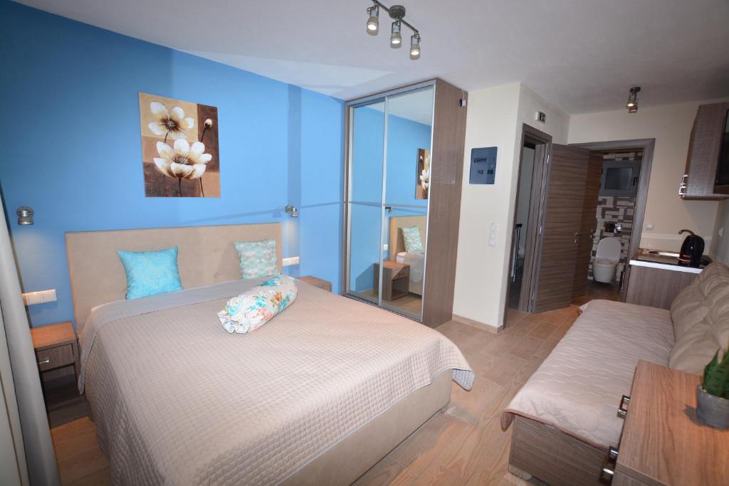 1 dormitorio con cama y pared azul en Studios Sotiria, en Limenas