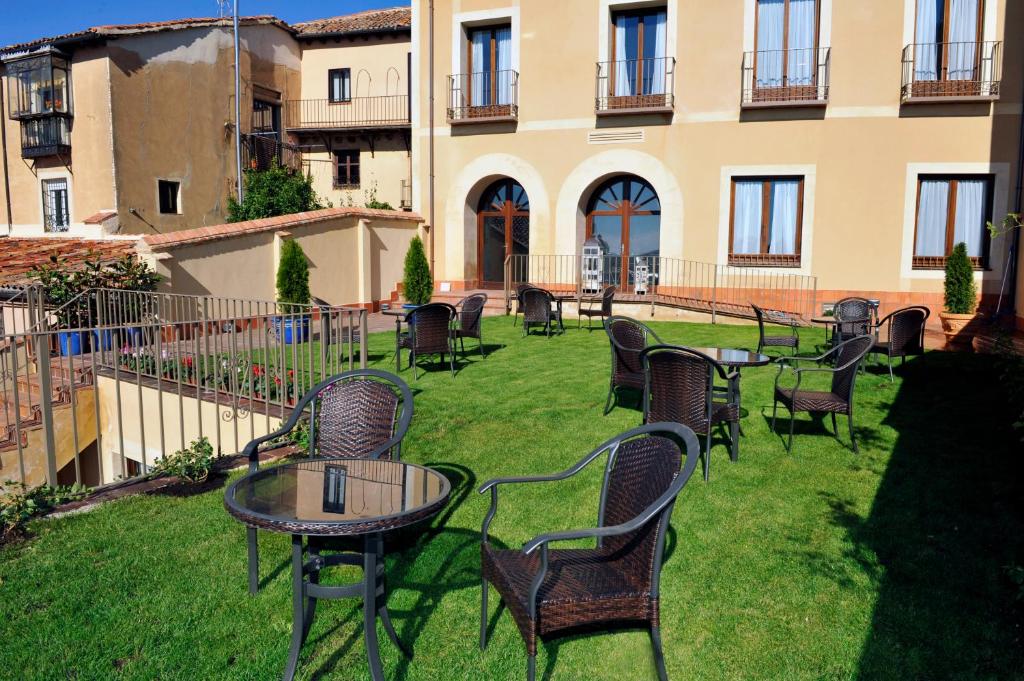 a garden area with a bench, chairs, and a horse in it at Hotel Don Felipe in Segovia