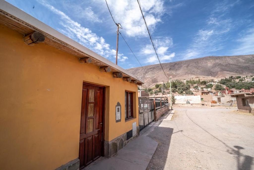 un edificio amarillo al lado de una calle en Cabañas Santa Catalina en Tilcara