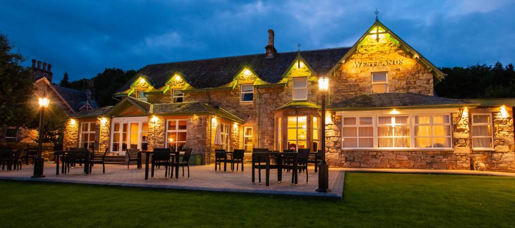 un gran edificio con mesas y sillas delante de él en Westlands of Pitlochry, en Pitlochry