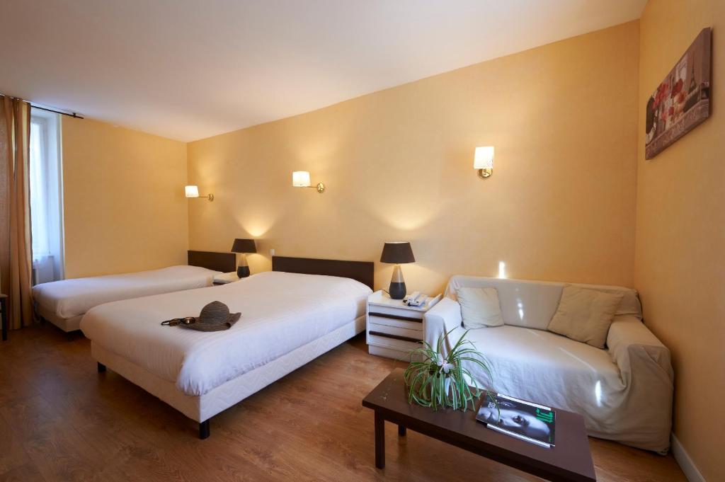 una camera d'albergo con due letti e un divano di Logis Hôtel Le Belle Rive a Najac