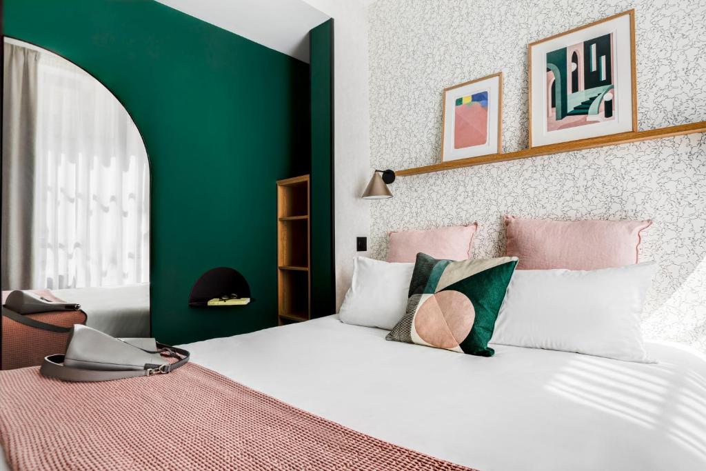 um quarto com uma cama branca e uma parede verde em Republik Hotel em Lyon