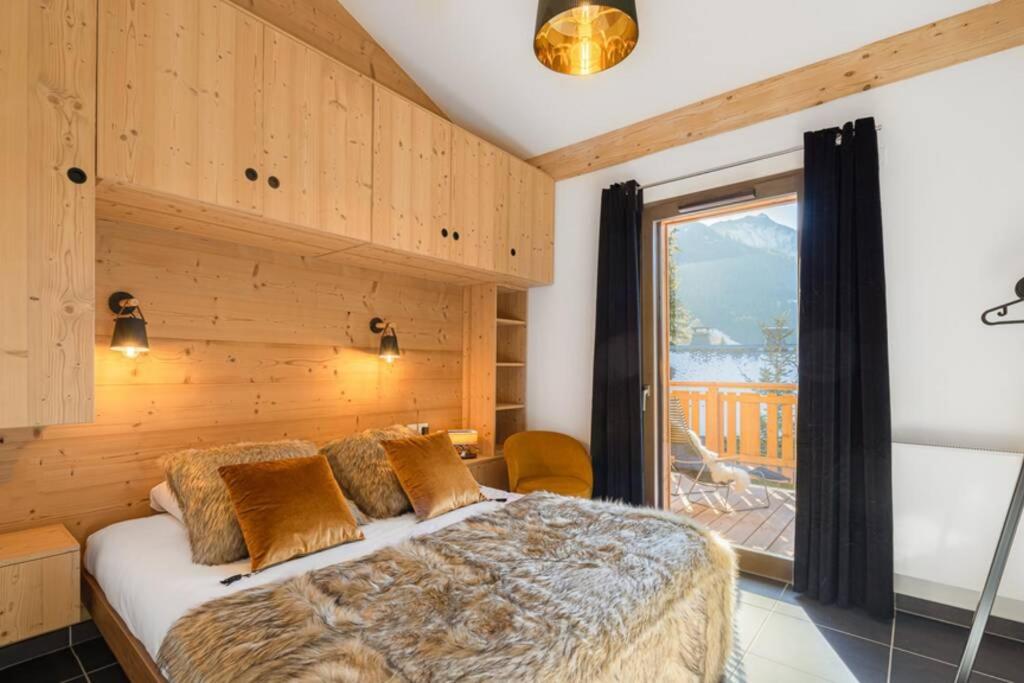 ein Schlafzimmer mit einem Bett und einem großen Fenster in der Unterkunft Les Freinets - Apt B201 - BO Immobilier in Châtel