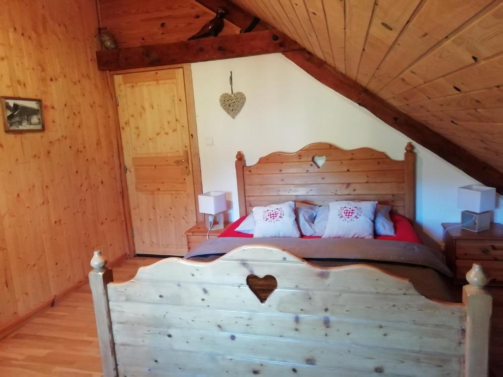 um quarto com uma cama de madeira num sótão em La Grange em Le Noyer
