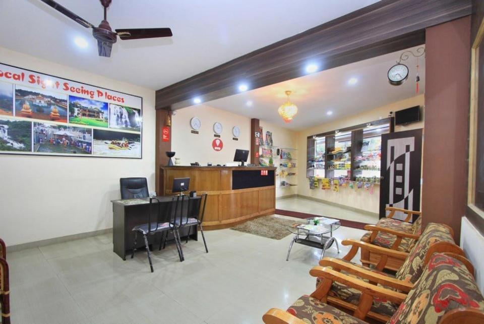a waiting area of a store with a couch and a table at Hotel City Comforts in Madikeri