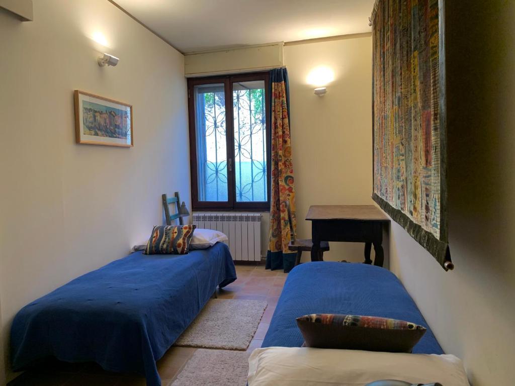 sypialnia z 2 łóżkami, stołem i oknem w obiekcie ARTISTICO - Artistic flat in front of GUGGENHEIM COLLECTION w Wenecji