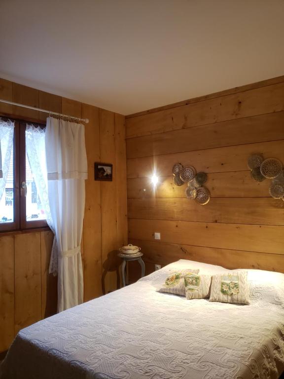a bedroom with a bed with a wooden wall at Les Chalets de la Garenne in La Ferté-Beauharnais