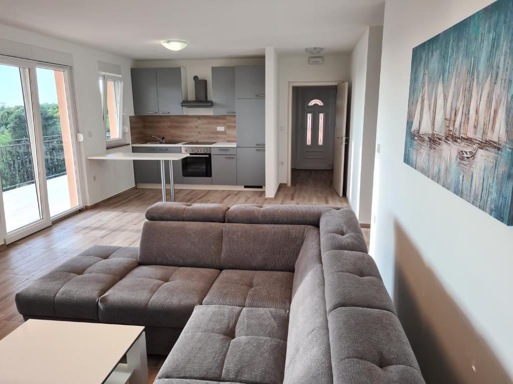 uma sala de estar com um sofá e uma cozinha em Apartments Patalic em Lopar
