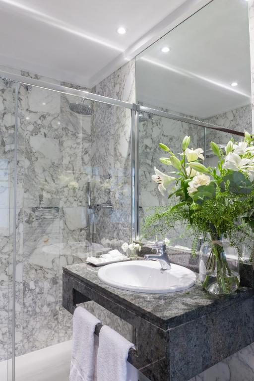 a bathroom with a sink and a vase of flowers at La Galería in Donostia-San Sebastián