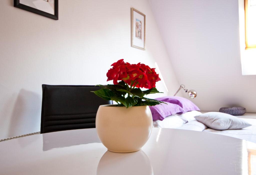 a vase with red flowers sitting on a table at Old Town Riga in Rīga