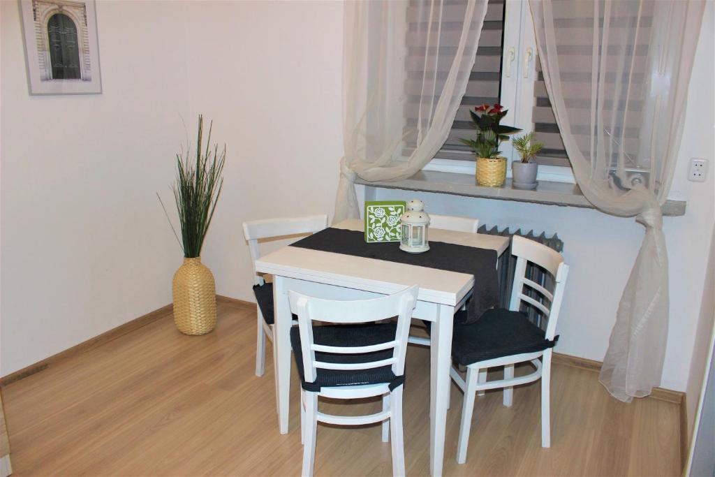 een witte tafel en stoelen in een kamer met een raam bij Dom Warszawa/Legionowo in Legionowo