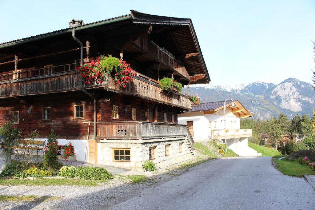 a large wooden building with flowers on the balcony at Ferienhaus Weberhof in Reith im Alpbachtal