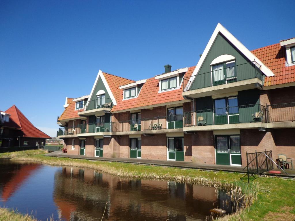 un edificio de apartamentos junto a un cuerpo de agua en De Rijper Eilanden en De Rijp