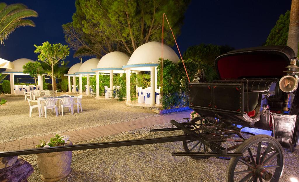 an old horse drawn carriage in front of a restaurant at Residence Regina in Marina di Gioiosa Ionica