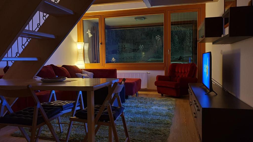 ein Wohnzimmer mit einem Tisch und einem Sofa in der Unterkunft Winter dream Bjelasnica in Bjelašnica