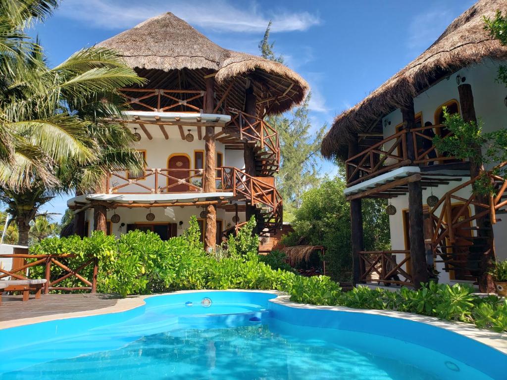 a villa with a swimming pool in front of a house at Casa Hridaya Hotel Boutique in Holbox Island