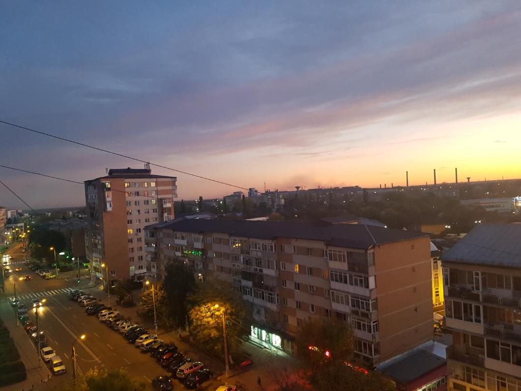 una vista de la ciudad por la noche con coches aparcados en Apartament Terra en Târgovişte