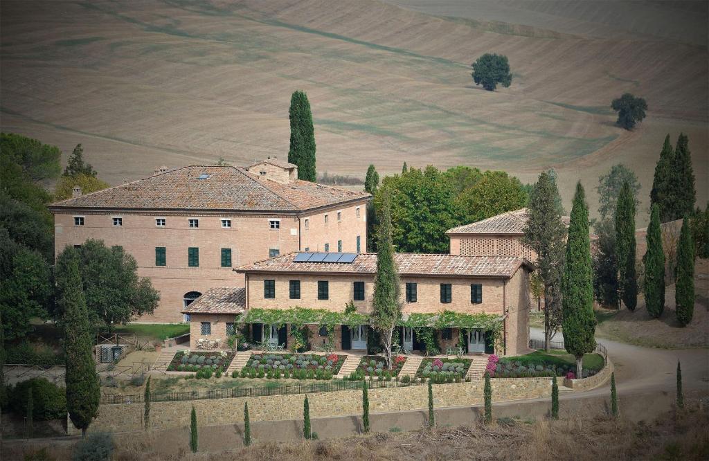 una casa grande con árboles frente a un campo en Villa Sant'Alberto, en Monteroni dʼArbia