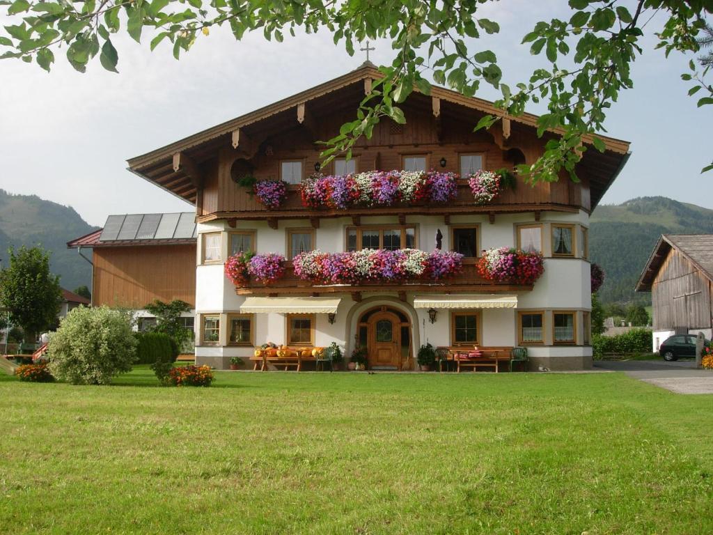 una casa con flores en la parte delantera en Hüttschmiedhof en Kössen