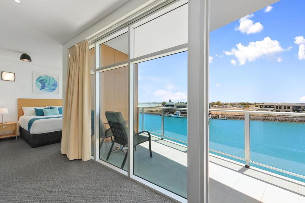 a bedroom with a bed and a balcony with a view at Wallaroo Marina Sea Vu Apartment in Wallaroo