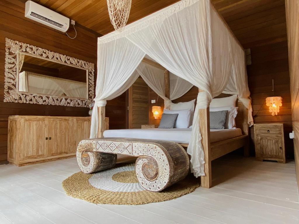 a bedroom with a canopy bed with a wooden ceiling at Met House in Thulusdhoo