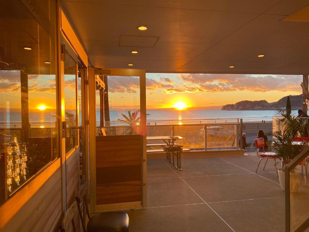 einen Balkon mit Blick auf das Meer bei Sonnenuntergang in der Unterkunft GOOD MORNING ZAIMOKUZA in Kamakura