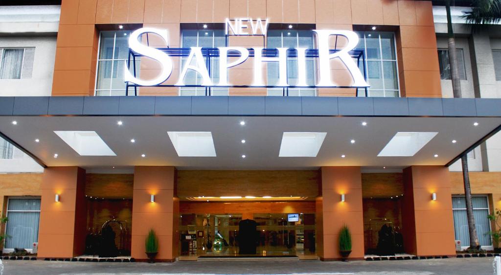 a building with a large sign on top of it at Hotel New Saphir Yogyakarta in Yogyakarta