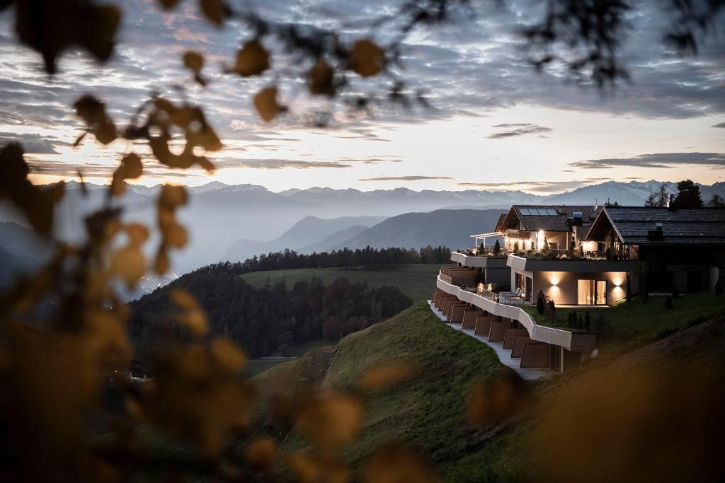 a building on a hill with lights on at Gfell in Vols am Schlern